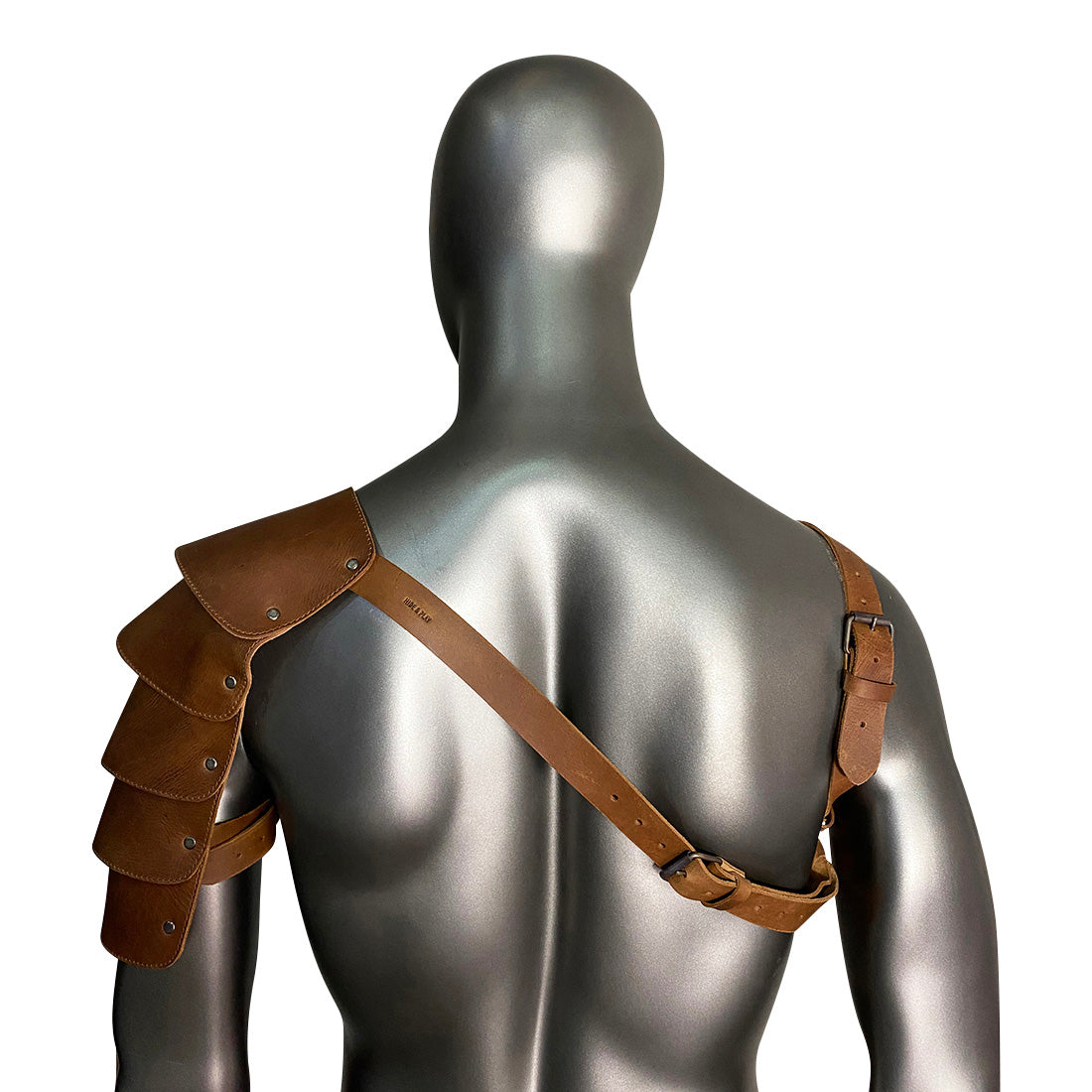 A close-up of the Hide & Play Single Shoulder Cover, showcasing its unique arm shield design. Ideal for costume enthusiasts, this full grain leather piece is adjustable thanks to its chest and back belts, perfect for Renaissance fairs. Handmade in La Antigua Guatemala, it reflects artisan quality and craftsmanship.