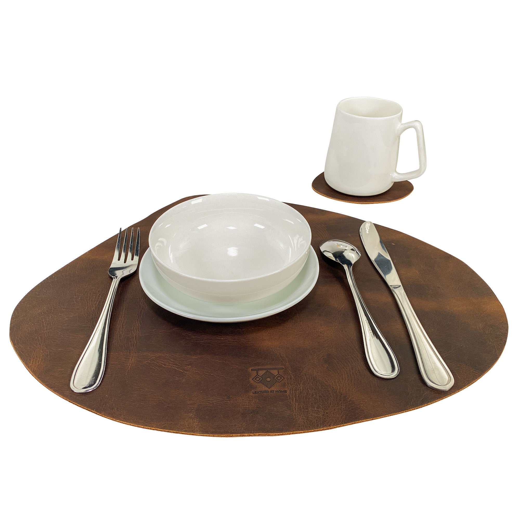 Leather Place Mats with Coasters Set of 4 by Leather At Home, elegantly set on a dining table with silverware and plates. These rustic and decorative kitchen table mats are handmade from full grain leather, making them a chic essential for your home, crafted in La Antigua Guatemala & Oaxaca Mexico.