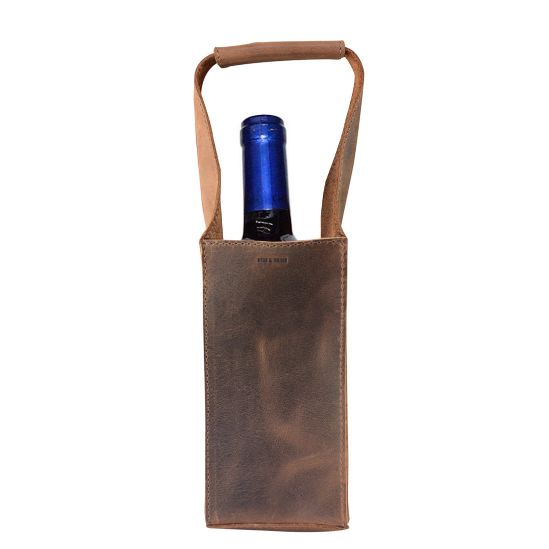 Bottle Wine Carrier by Hide & Drink, showcasing a squared design with a handle. This rustic case serves as a Bordeaux bottle holder and a stylish carry-on pouch, perfect for picnic accessories. Made from full grain leather, it reflects small batch production with its hand cut and hand sewn craftsmanship, fire branded by artisans in La Antigua Guatemala and Oaxaca Mexico.