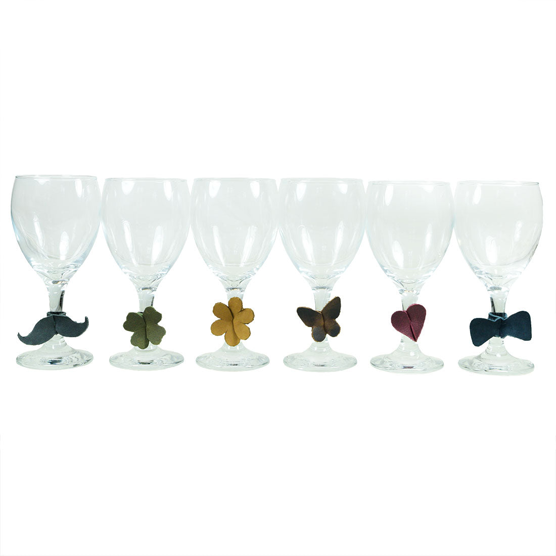 Drink Tags (6 Pieces) by Hide & Drink featuring a set of six unique leather wine glass tags including mustaches, flowers, hearts, and bows. These Drink Markers serve as stylish napkin rings and glass identification tools, ideal for parties. Made from Full Grain Leather through small batch production, each tag is hand cut, hand sewn, and fire branded by artisans in La Antigua Guatemala & Oaxaca Mexico.