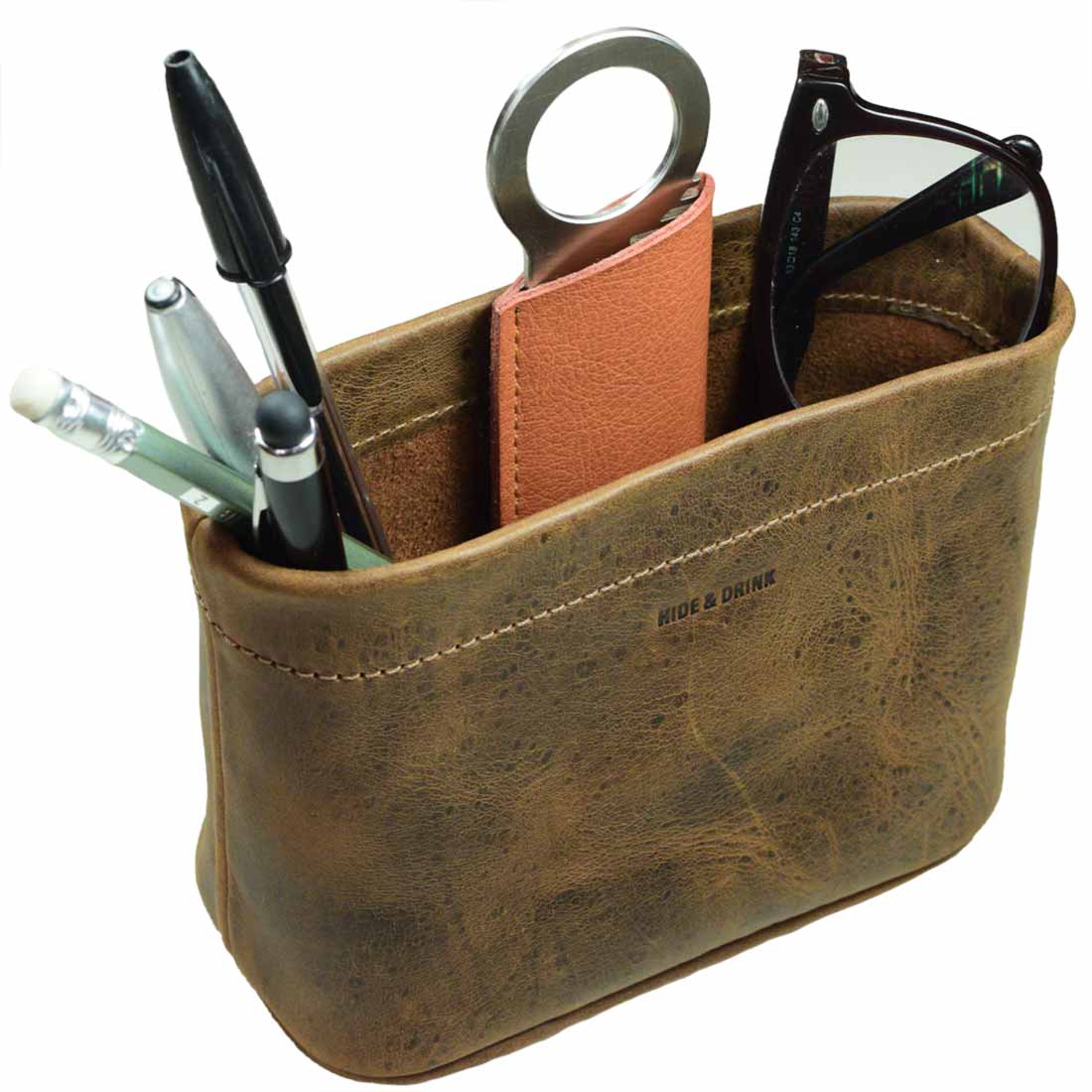 A stylish Desk Organizer Bag from Hide & Drink featuring various pens and office supplies, crafted from Full Grain Leather. This versatile pen holder, perfect for keeping your desk organized, showcases artisan craftsmanship and is handmade in La Antigua Guatemala & Oaxaca Mexico.
