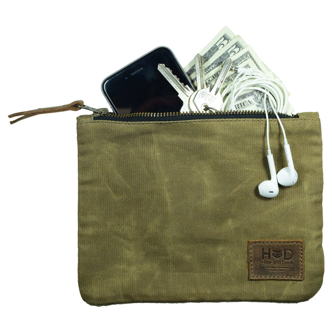 A Waxed Zippered Pouch from Hide & Drink filled with cash, keys, and earbuds, showcasing its practical design as a multipurpose bag. This Canvas Zippered Pouch is handmade in La Antigua Guatemala, made from durable waxed canvas and full grain leather, perfect for travel accessories.