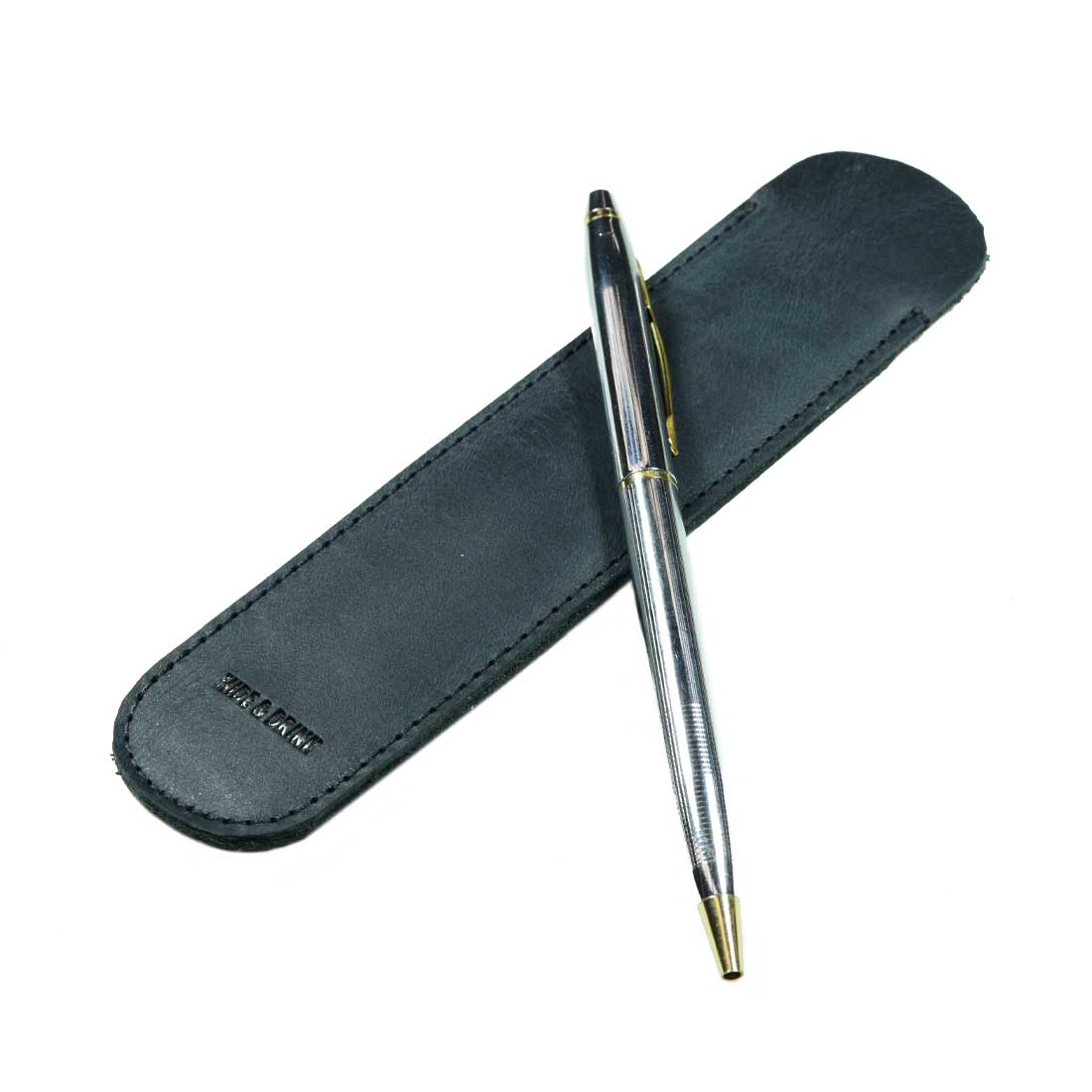 A Vintage Pen Sleeve from Hide & Drink displayed with a pen on a dark background, illustrating its modern design and function as an office essential. Each sleeve is meticulously handmade using high-quality Full Grain Leather.