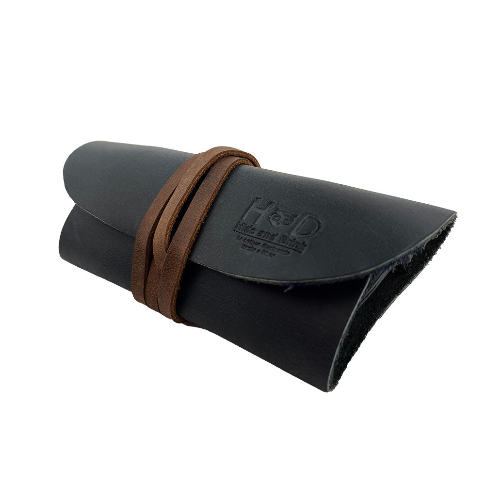 Hide & Drink Leather Sunglass Wrap showcases a unique design for sunglasses storage. Made from luxurious full grain leather, this eye glasses storage solution is perfect for travel, reflecting the artistry of small batch production.