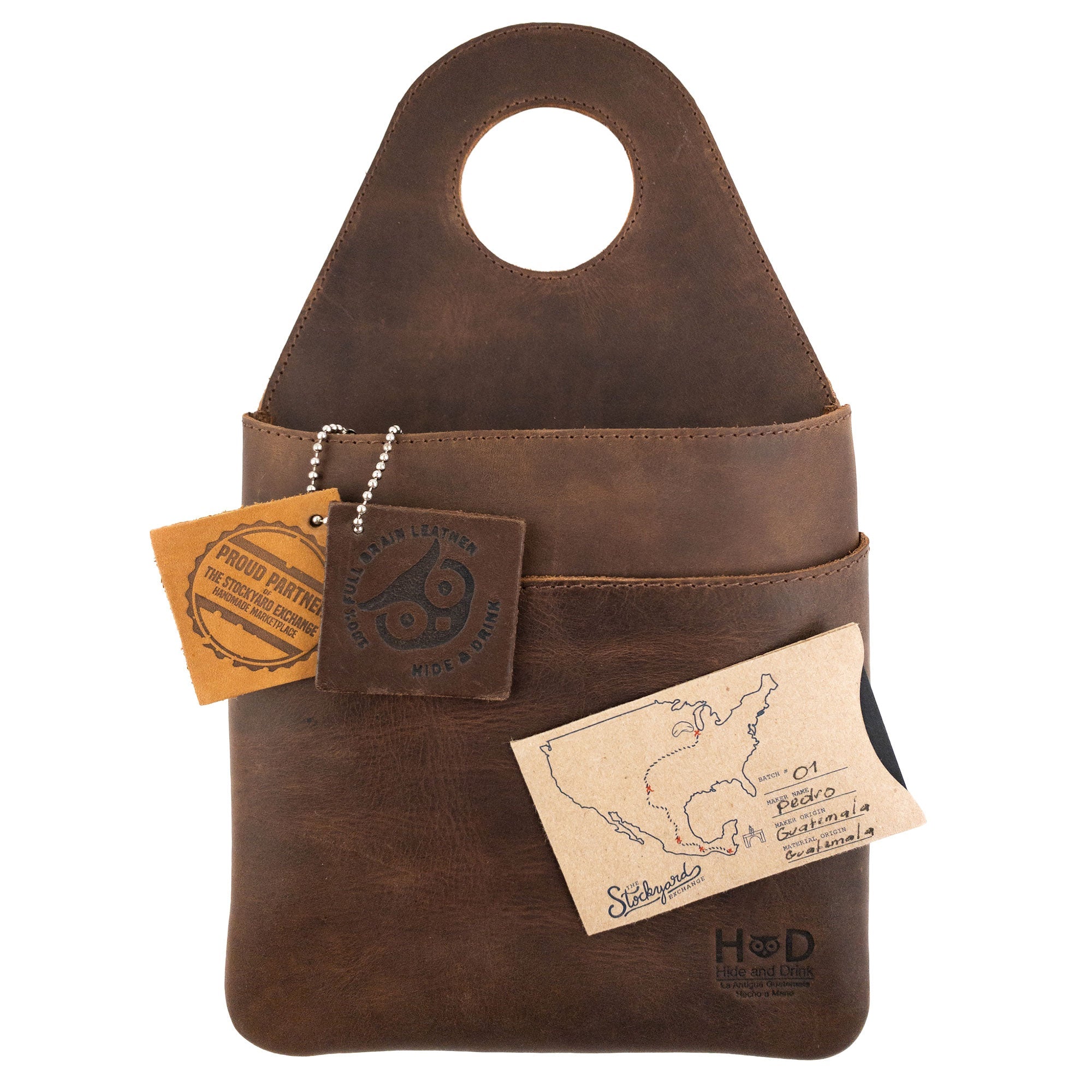 Hide & Drink's Seat Side Organizer for Gear Stick features product tags highlighting its Full Grain Leather quality. This organizer serves as a holder for charges, cables, and essentials, and is also an outdoor protector for knives. With its handmade charm, it represents small batch production, hand cut, hand sewn, and fire branded craftsmanship from artisans in La Antigua Guatemala & Oaxaca Mexico.